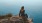 woman sits on rock ledge and looks across Saratoga Lake